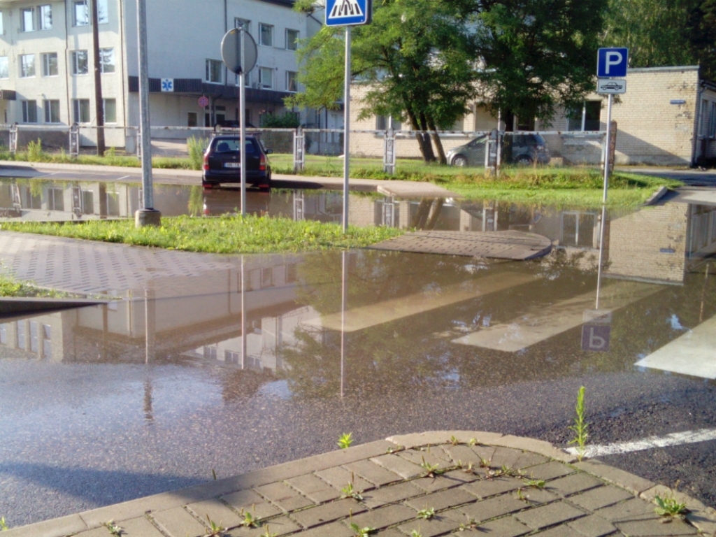 Autovadītājs: Stāvlaukumā pie Jēkabpils slimnīcas peļķes neaiztek kanalizācijā, bet stāv kamēr izžūst (FOTO)(PAPILDINĀTS)